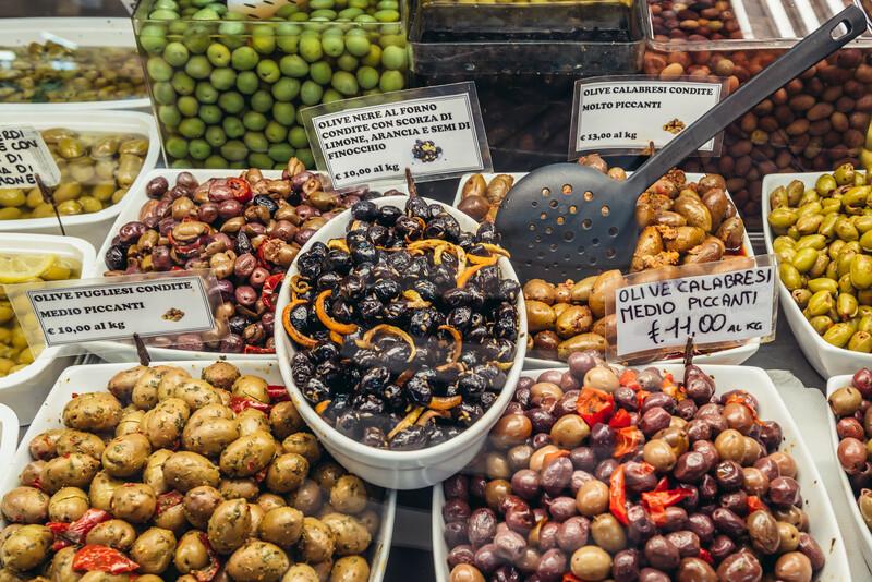 Varieties of olives for sale on covered food market - Mercato Delle Erbe in historic part of Bologna city, Italy